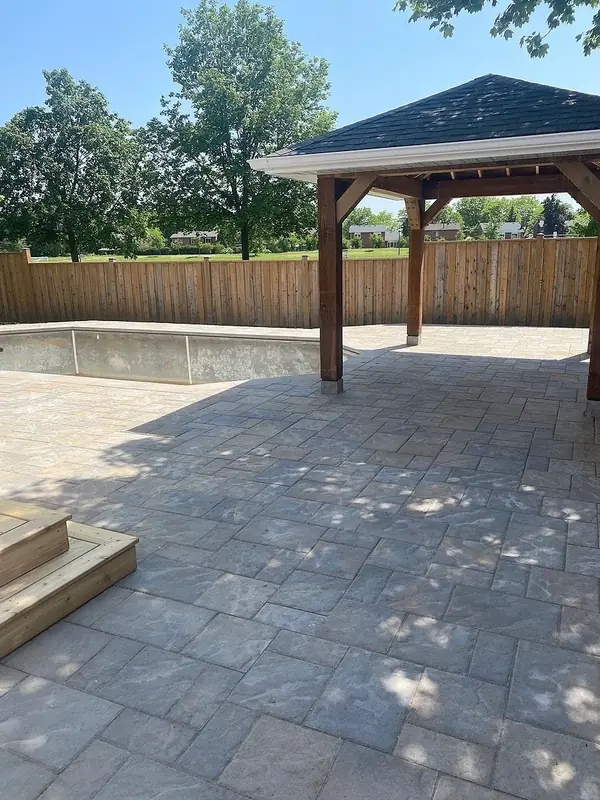 Paver patio under a new timber pavilion with a stone step up